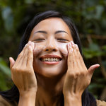 Woman rubbing cleanser into her face while smiling